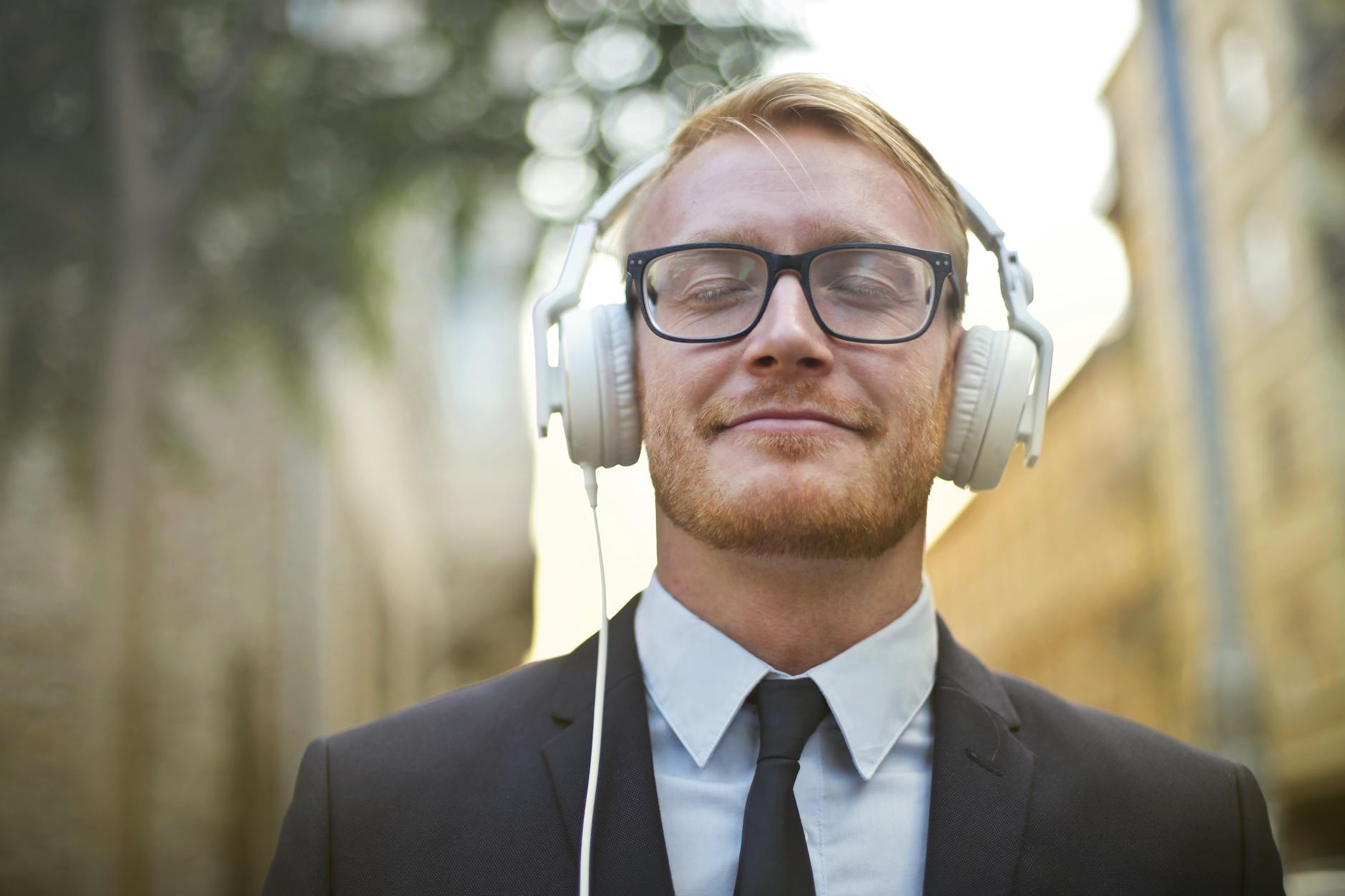 cheerful man in formal wear enjoying music